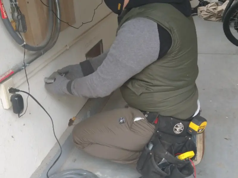Electrician performing outlet wiring in a Azalea Park garage